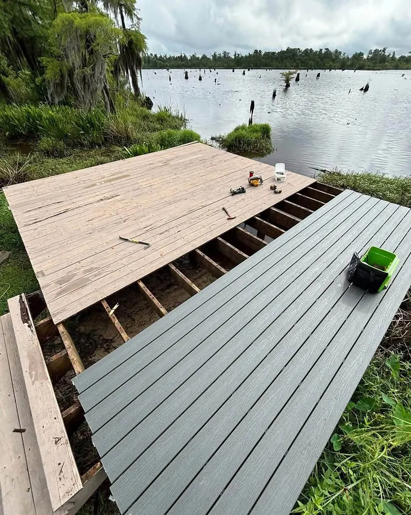 Deck being resurfaced beside a lake, with weathered boards, exposed joists and new gray composite decking