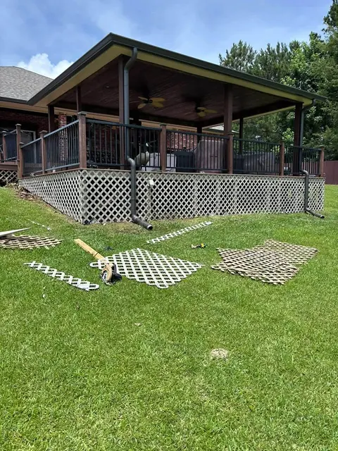 Covered deck with lattice skirting panels laid out on the lawn during installation
