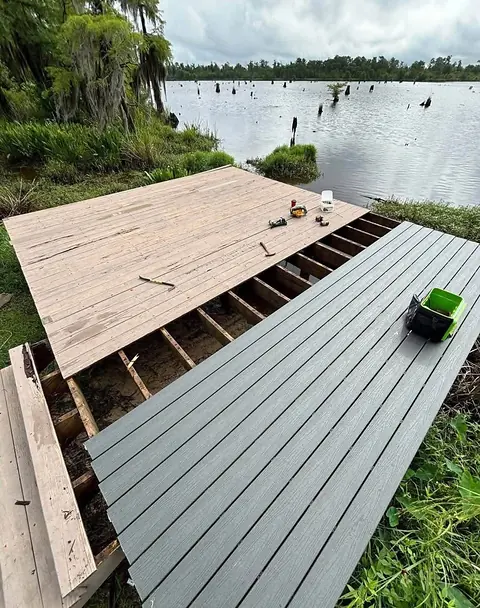 New gray composite deck boards laid next to old weathered boards, with joists exposed between them