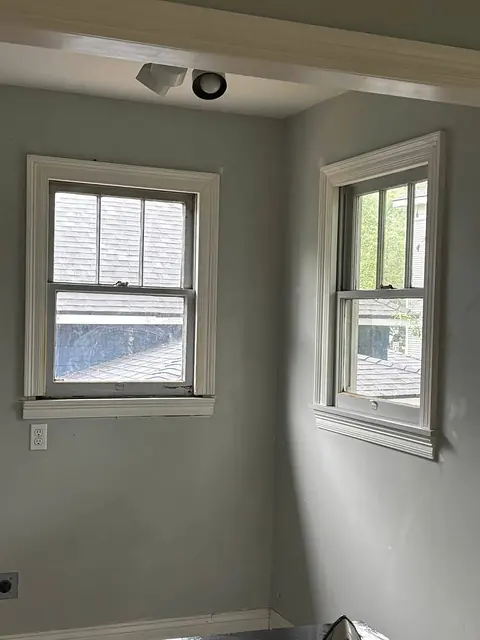 Room corner with two white-trimmed windows after renovation