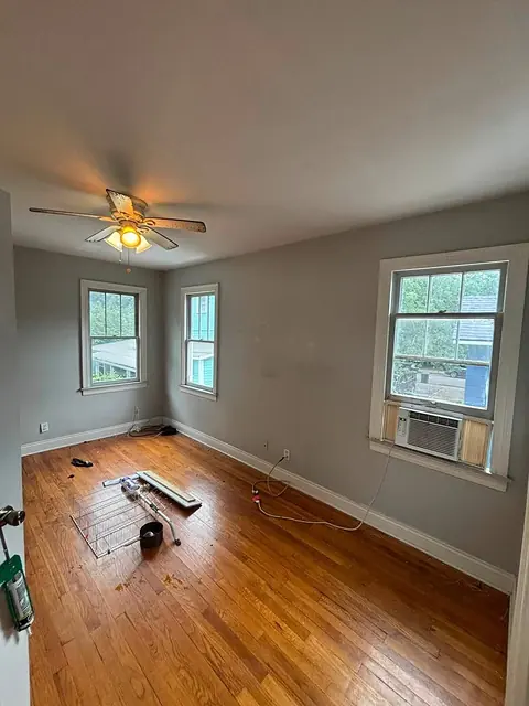 Bedroom with hardwood floor and tools set out during renovation