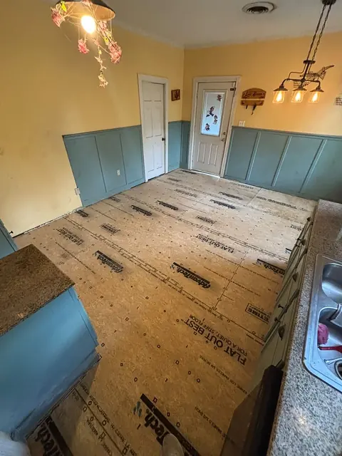 New subfloor panels installed across a kitchen floor