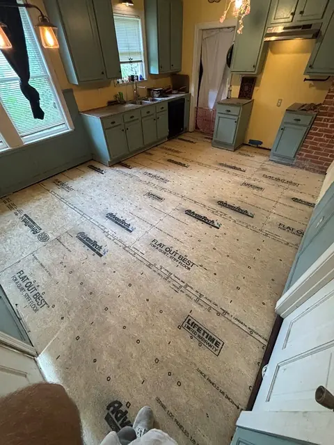 Kitchen with new subfloor sheathing installed wall to wall